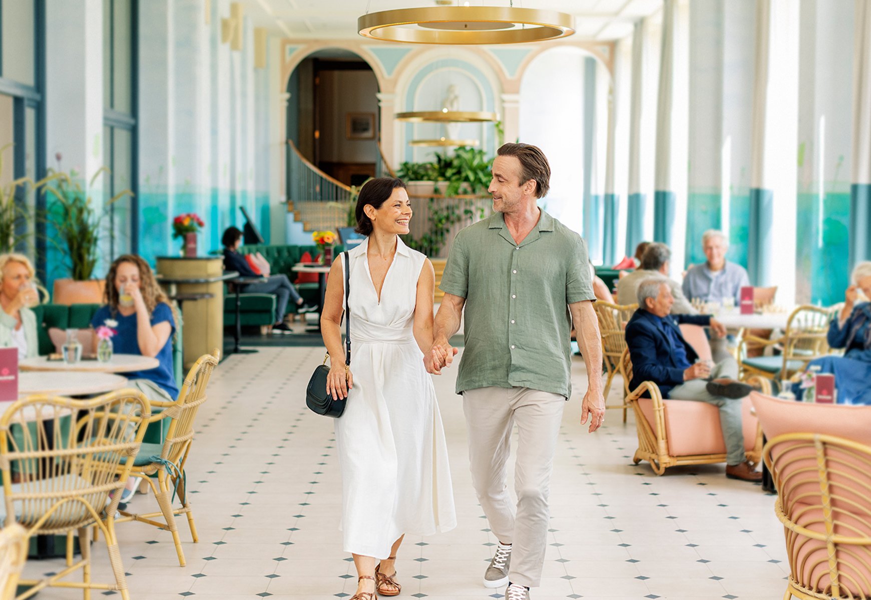 Mick and Angie walking towards the camera through the Orangery at Heythrop Park, a Warner Hotel